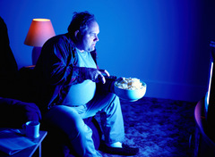Overweight man in front of TV