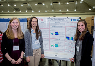 Three woman presenting a poster session